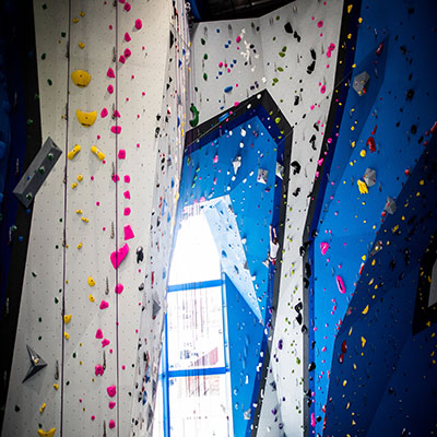 blue and gray rock climbing wall with rock climber